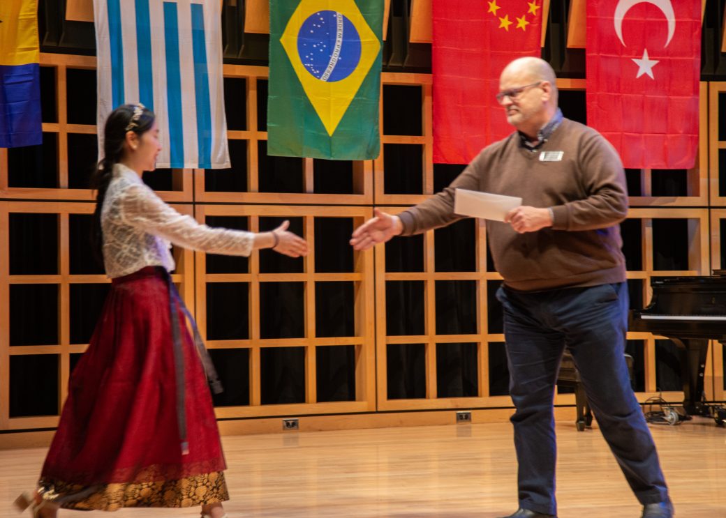 A man and a woman handshaking at International Student Club Coffeehouse 2023