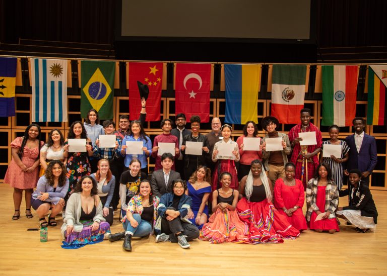 People smiling to the camera at International Student Club Coffeehouse 2023