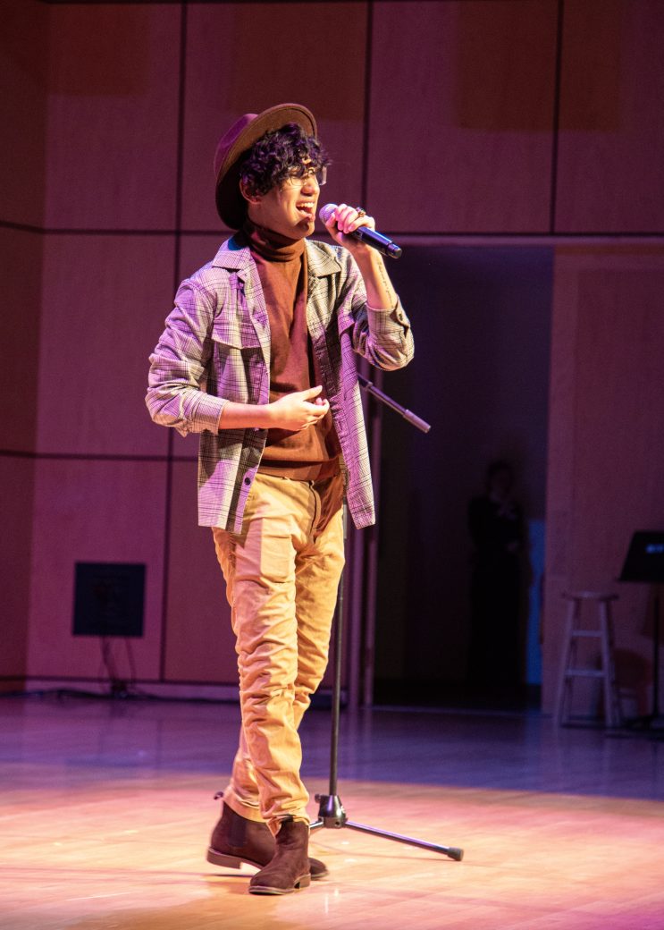 A man singing on the stage at International Student Club Coffeehouse 2023