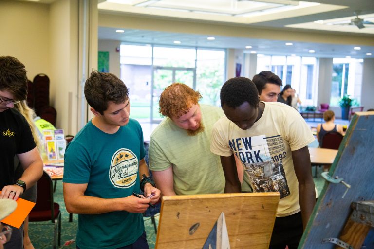 Three men looking at the board