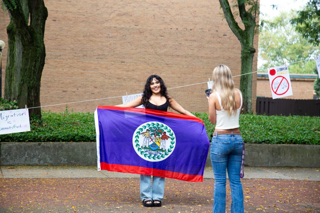 A woman with Belize's flag at Hispanic Heritage Month Convocation and Celebration