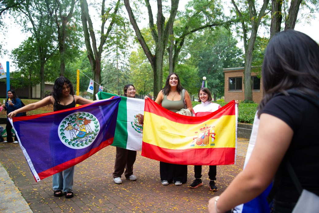 People with their countries' flags at Hispanic Heritage Month Convocation and Celebration
