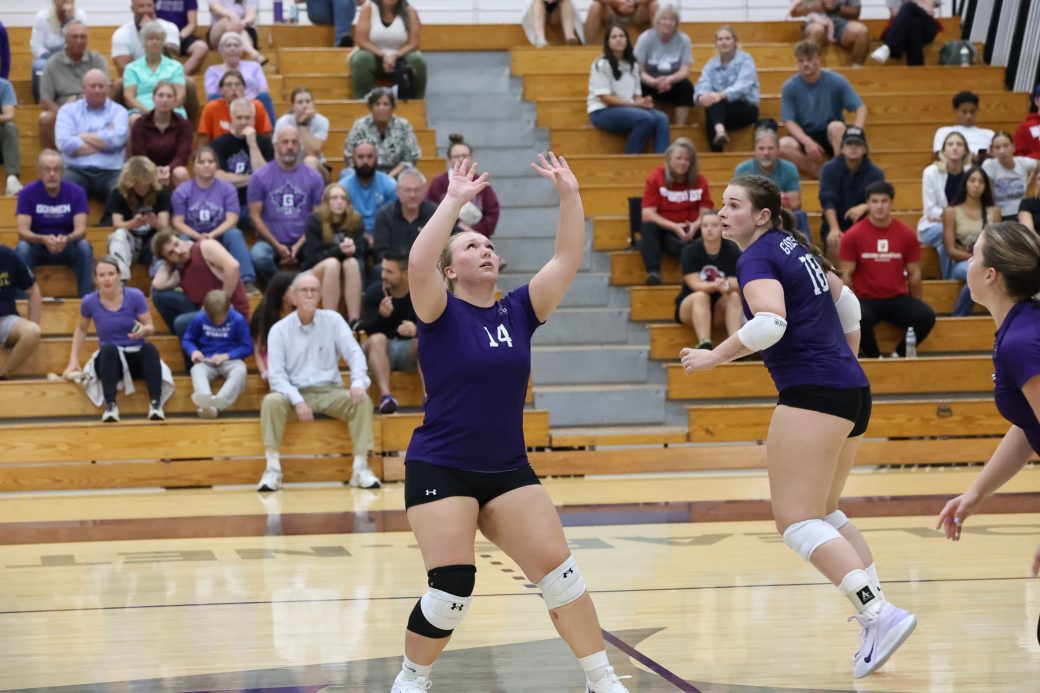 A Goshen College volleyball player sets