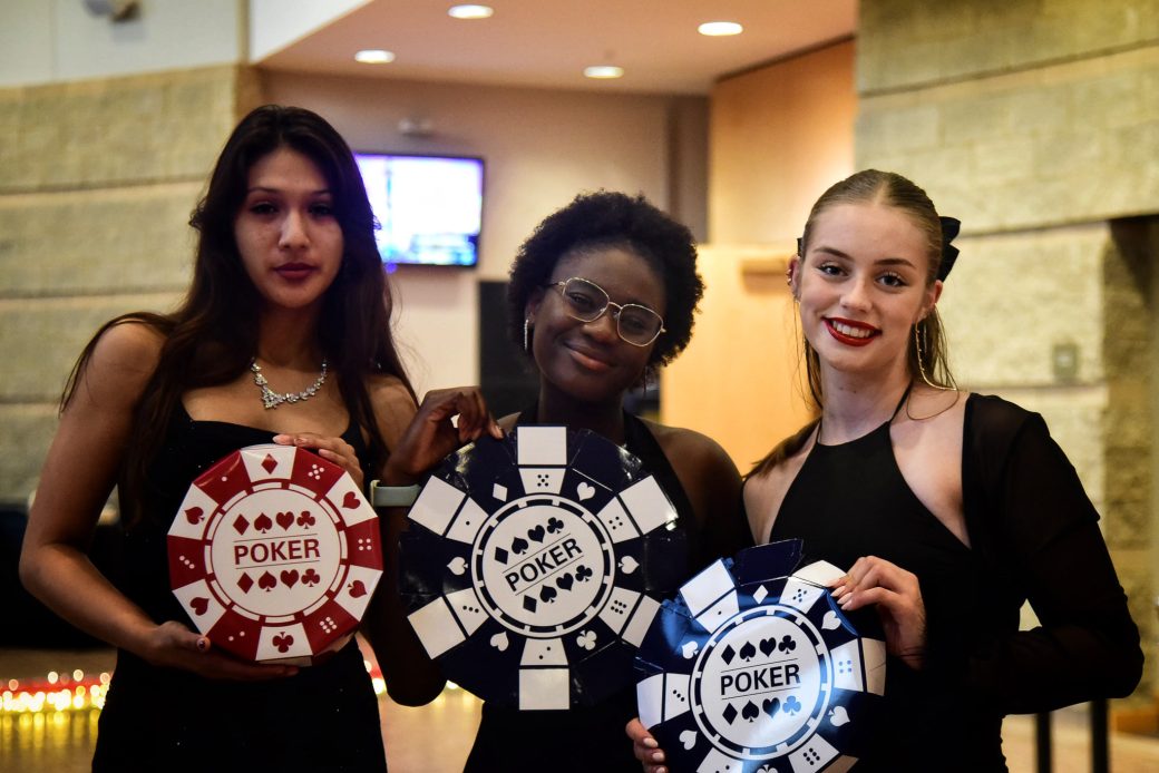 Three womans with poker tips smilling for the photo at 2025 Goshen's College kick off