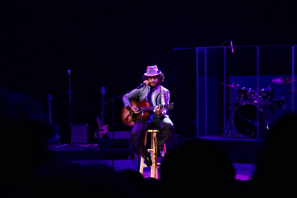 Man with an acoustic guitar at Goshen college stage