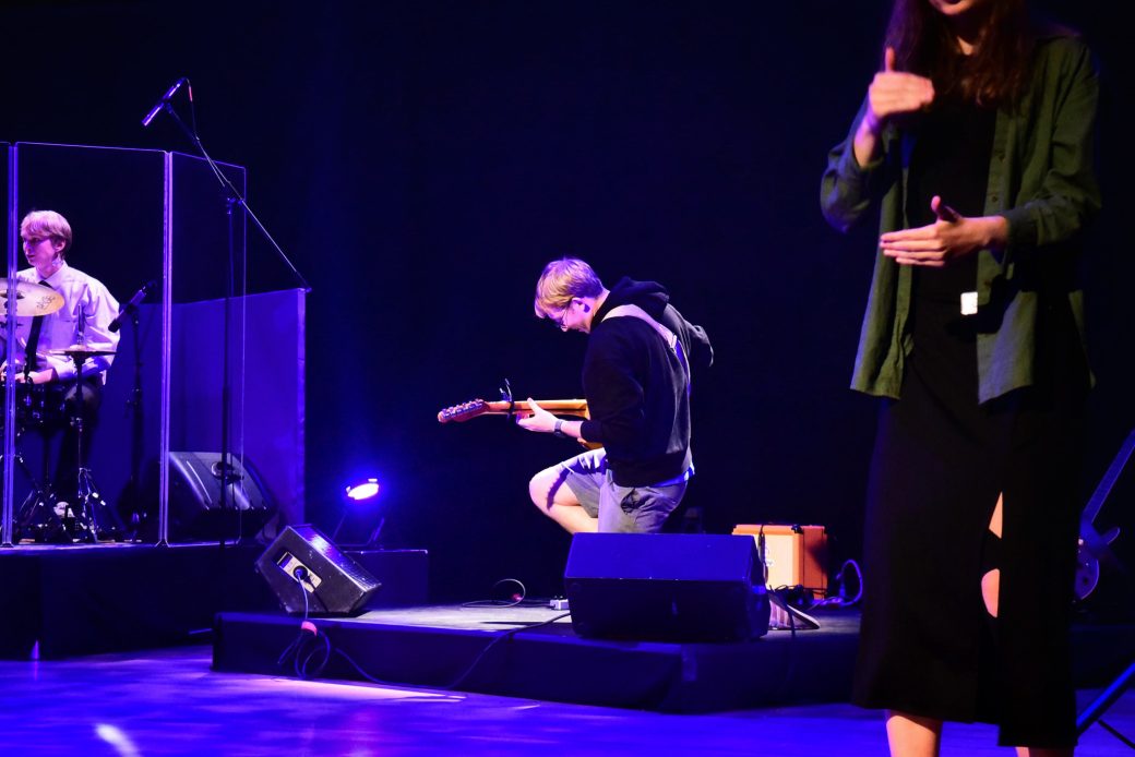 Man with Man with an acoustic guitar at Goshen college stage