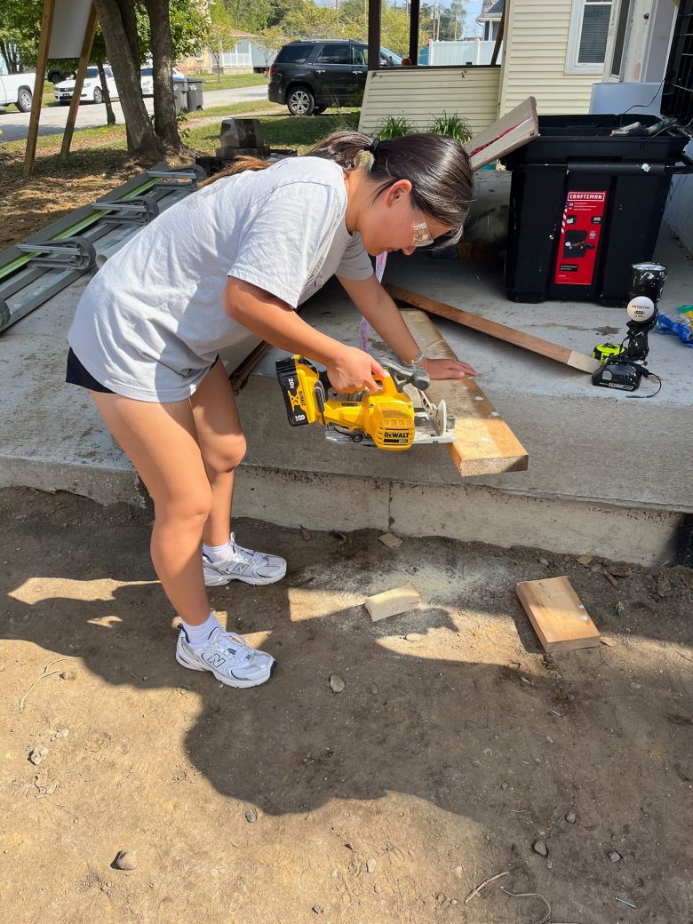 A woman cutting a wooden board