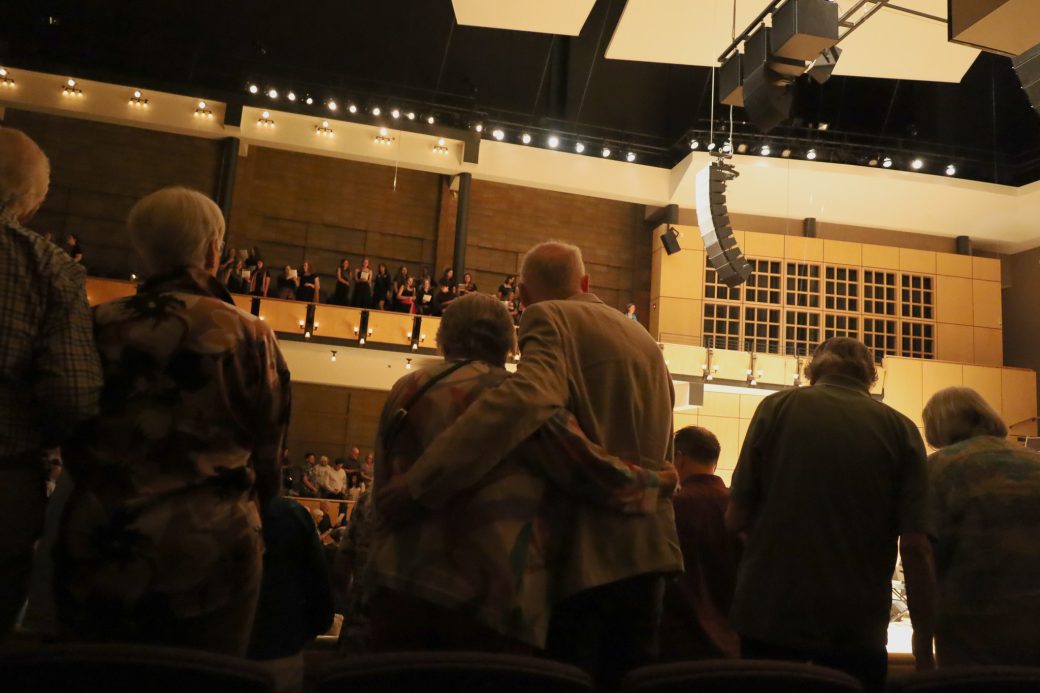 An older couple embraces while enjoying music performance