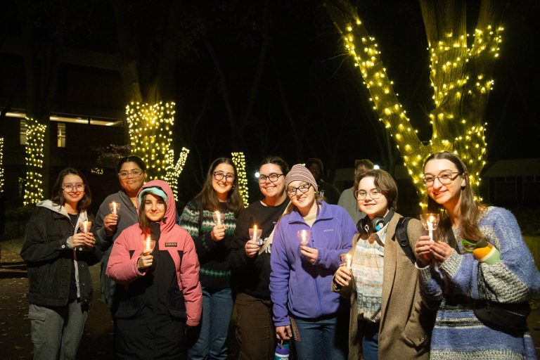 Group of people attending the tree lighting smile at the camera