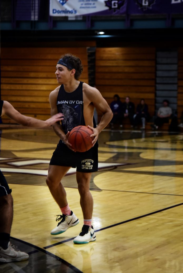 PLayer in black tank with basketball on court
