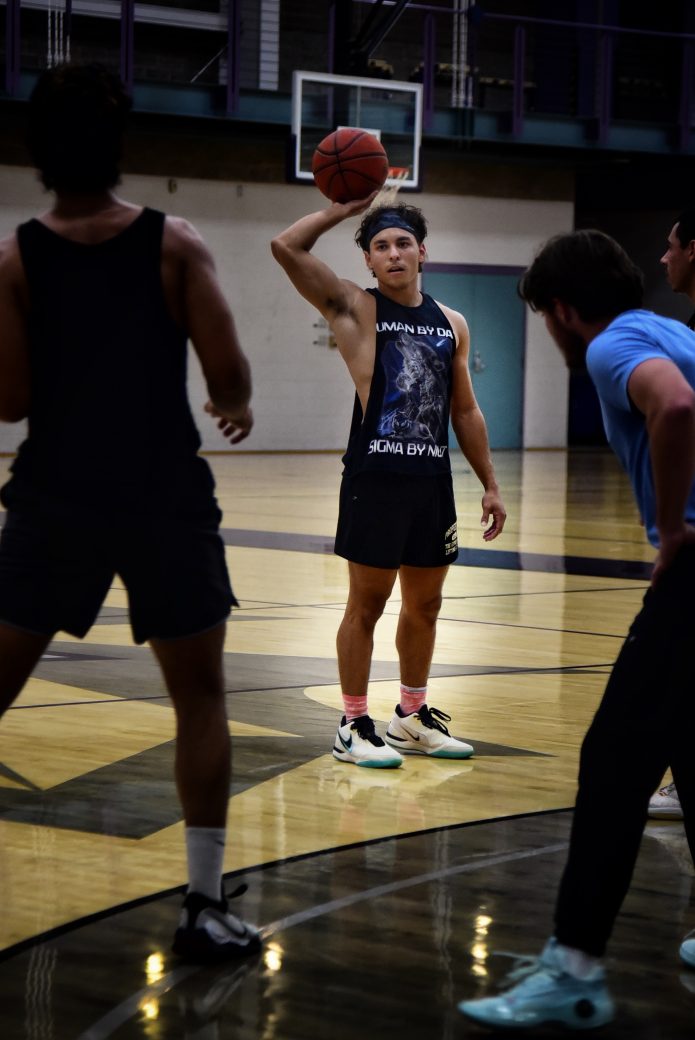 PLayer in black tank top passes ball to team mate.