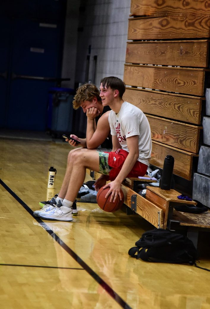 Two male players take a break on the sidelines