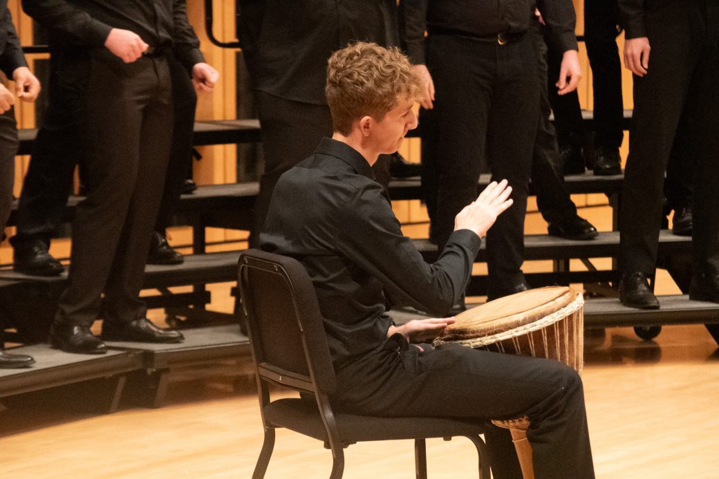 Drummer on stage at Fall concert accompanying Voices of the Earth choir