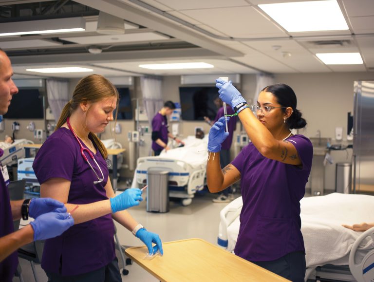 Nursing students practicing syringe skills in a new nursing lab.