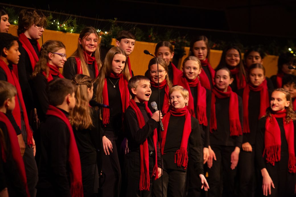 Child sings a solo with choir behind him