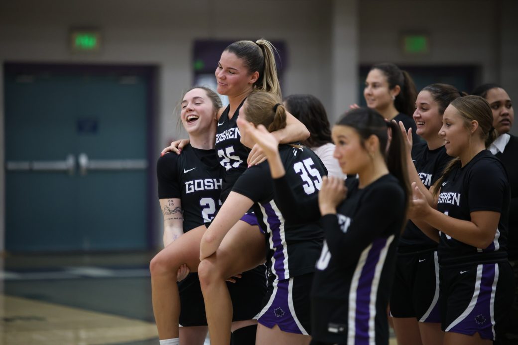 Female athletics team lifts player to celebrate