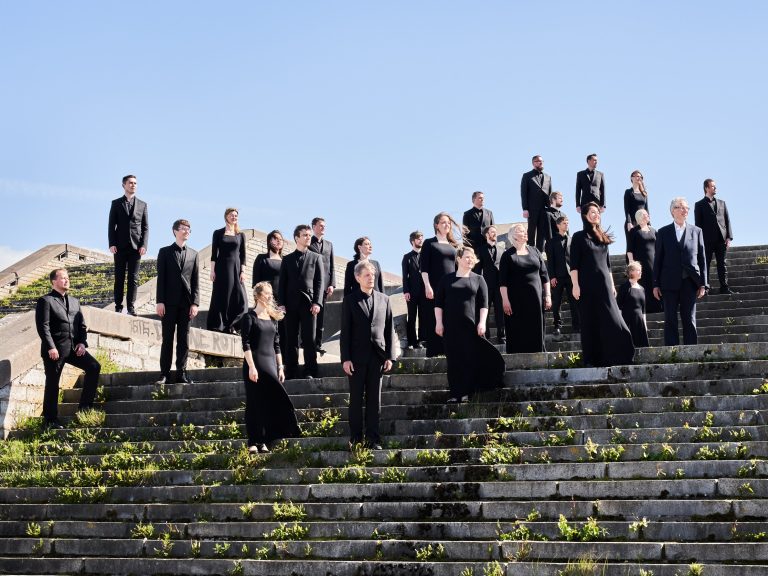 A choir poses on large stone steps