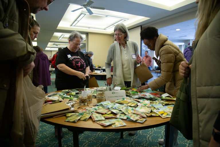 people standing around a table with seeds