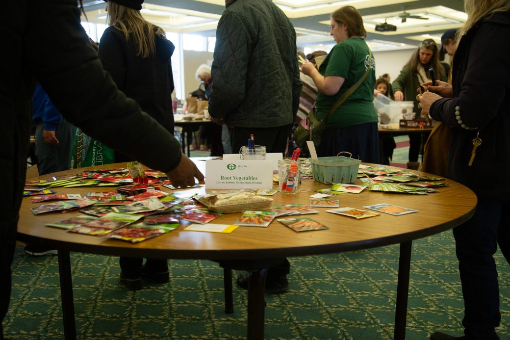 people standing around a table with seeds