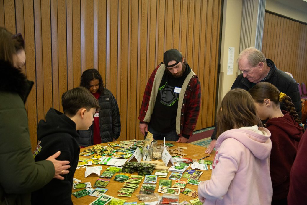 people standing around a table with seeds