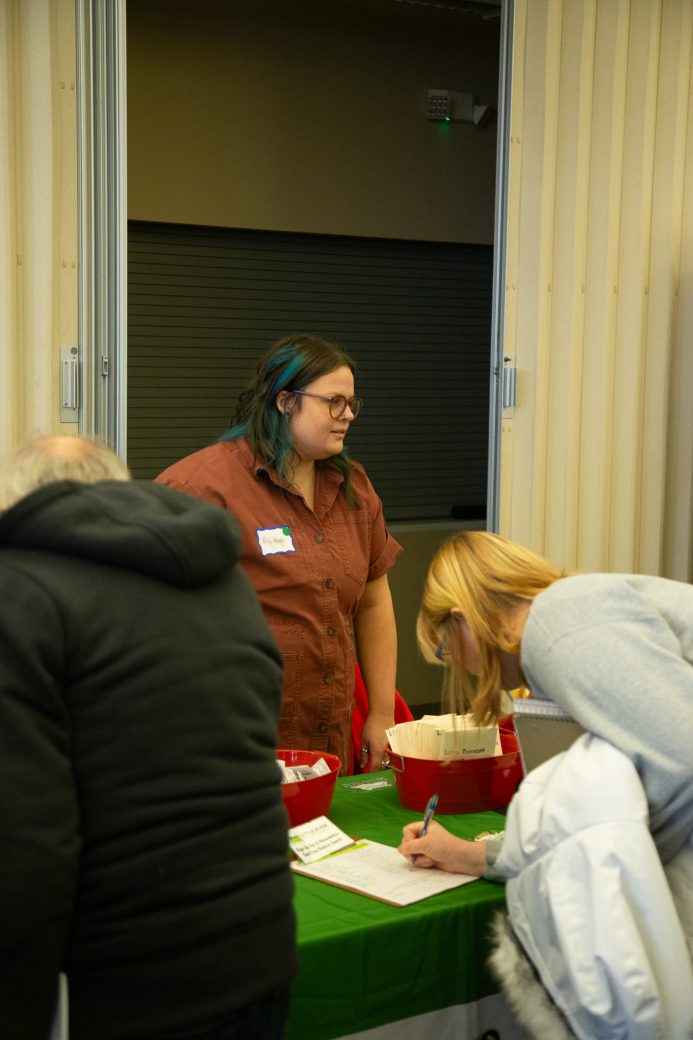 woman writing something on a clipboard on a table