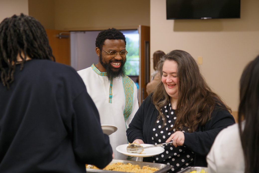 People smiling and getting food
