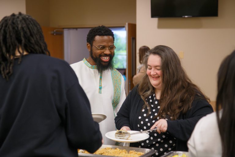 People smiling and getting food