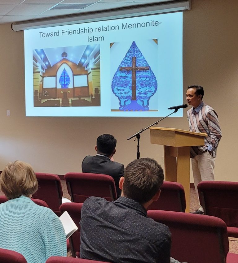 A man presenting from a lecturn