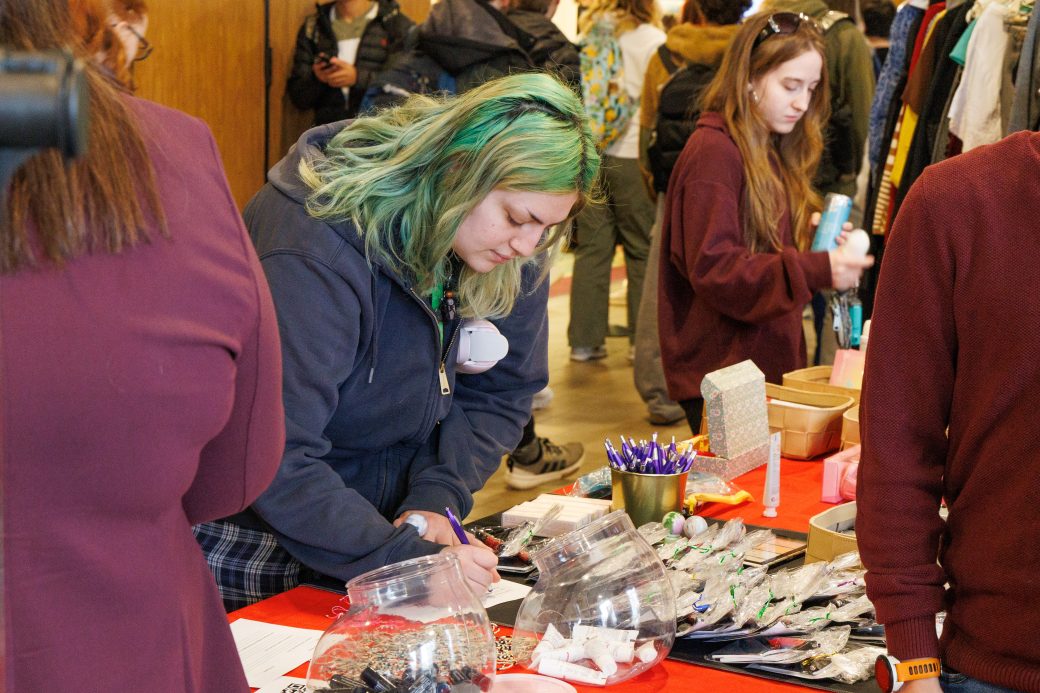 Student signs up at a booth.
