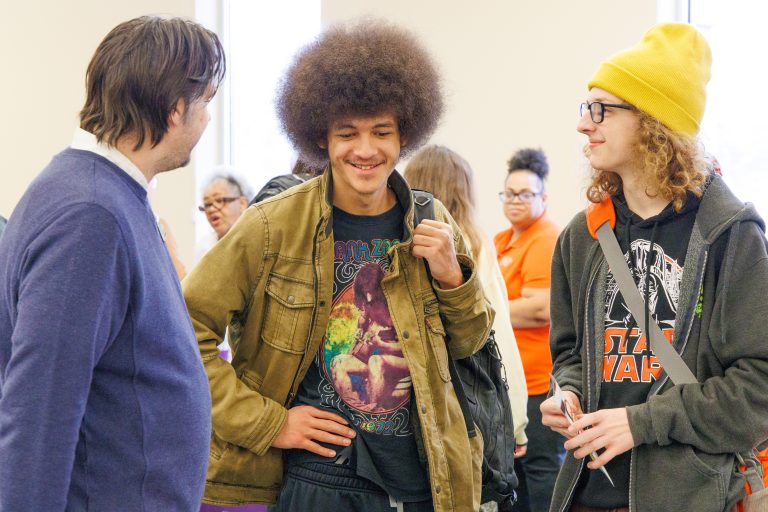 Students engage in conversation at booth.