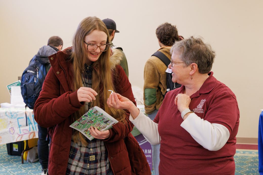 Community member handing out hershey kisses at booth.