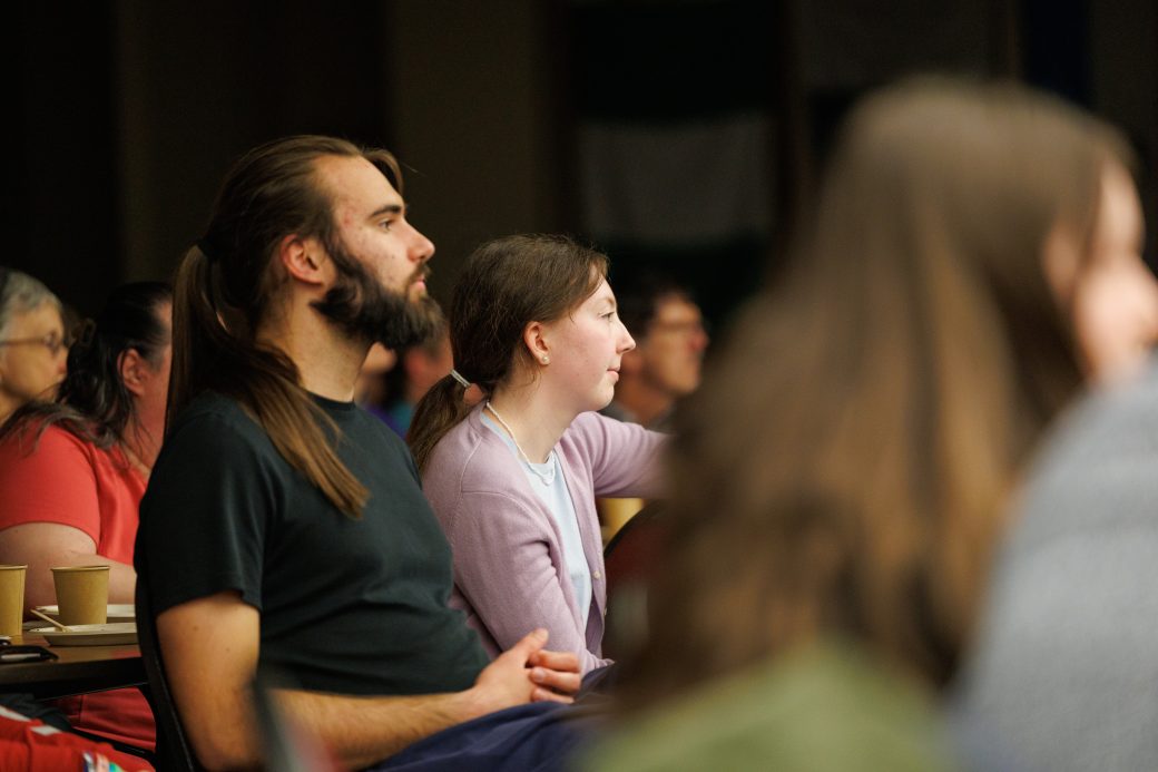Audience members watching performance