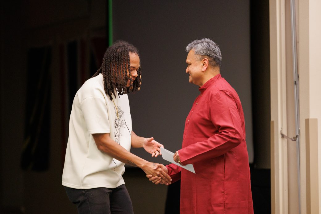 Man giving award to another man.