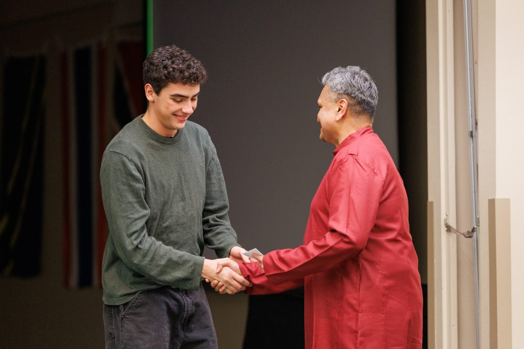 Man giving award to another man.