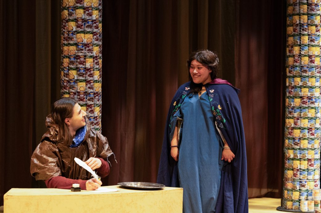 actors talking and writing with a quill