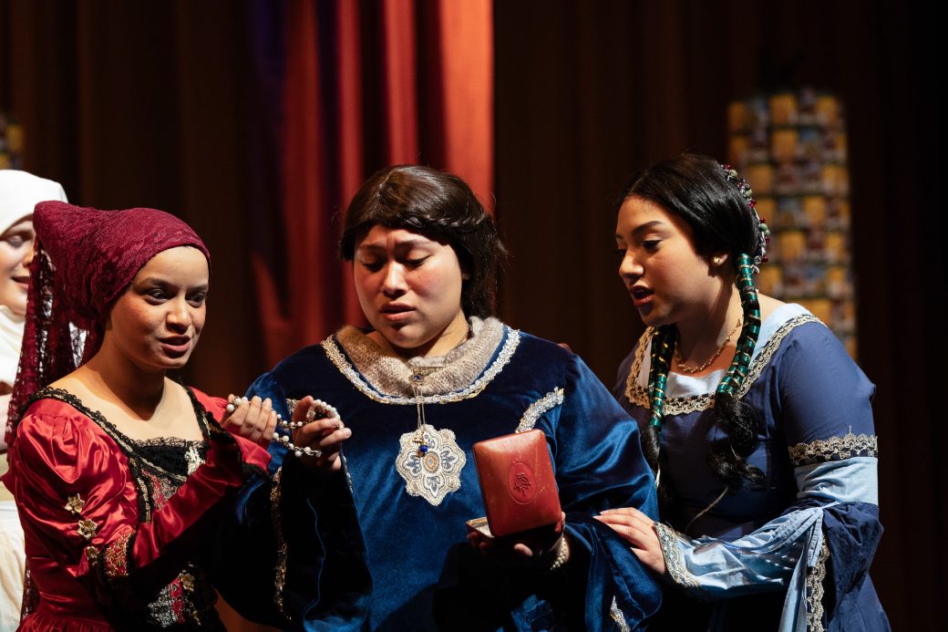 actors looking at a necklace