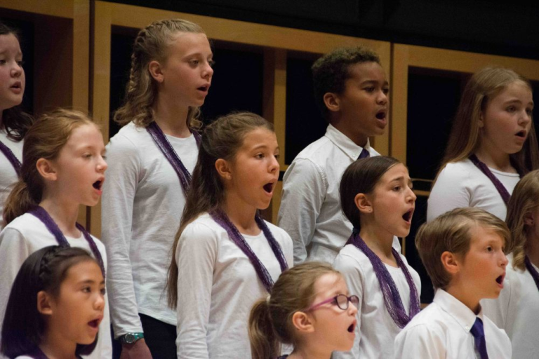 children dressed in white singing