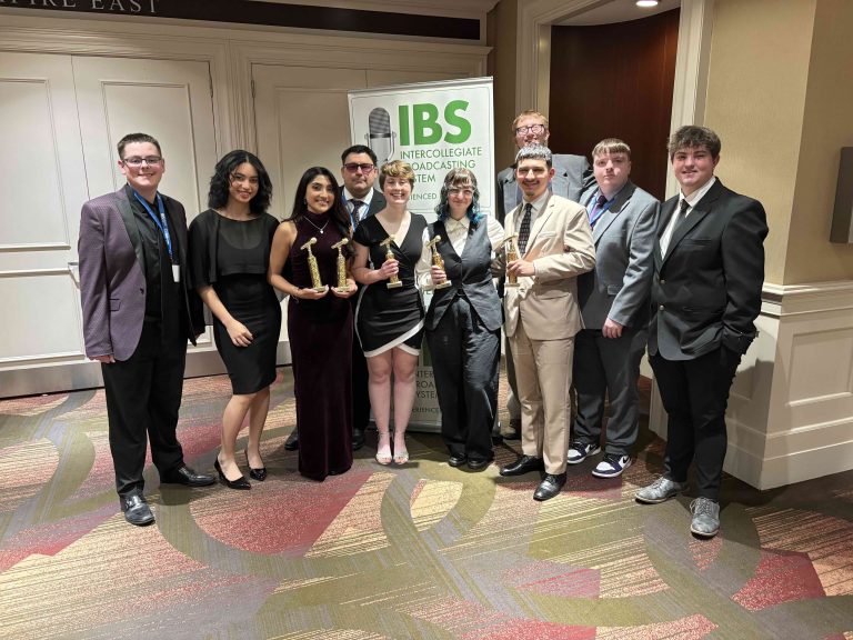 students pose in front of banner that reads "IBS"