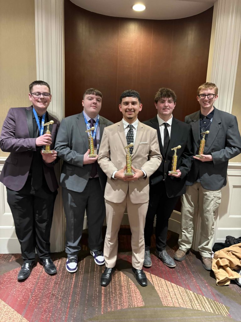 students hold small microphone-shaped trophies