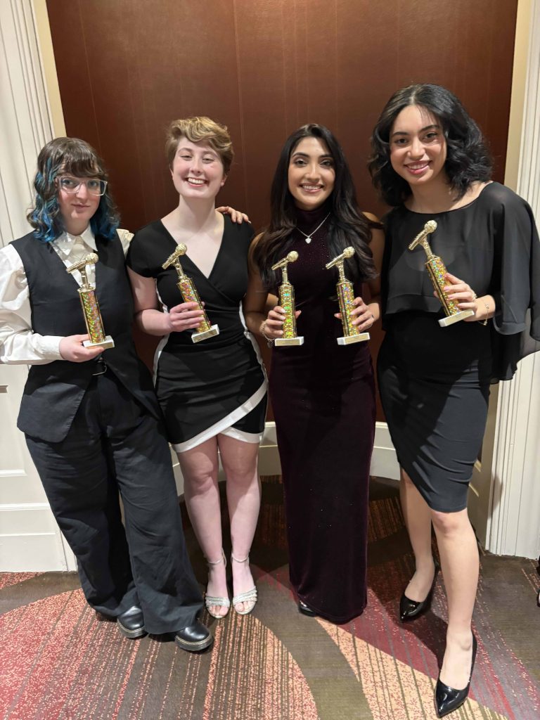 students hold small microphone-shaped trophies