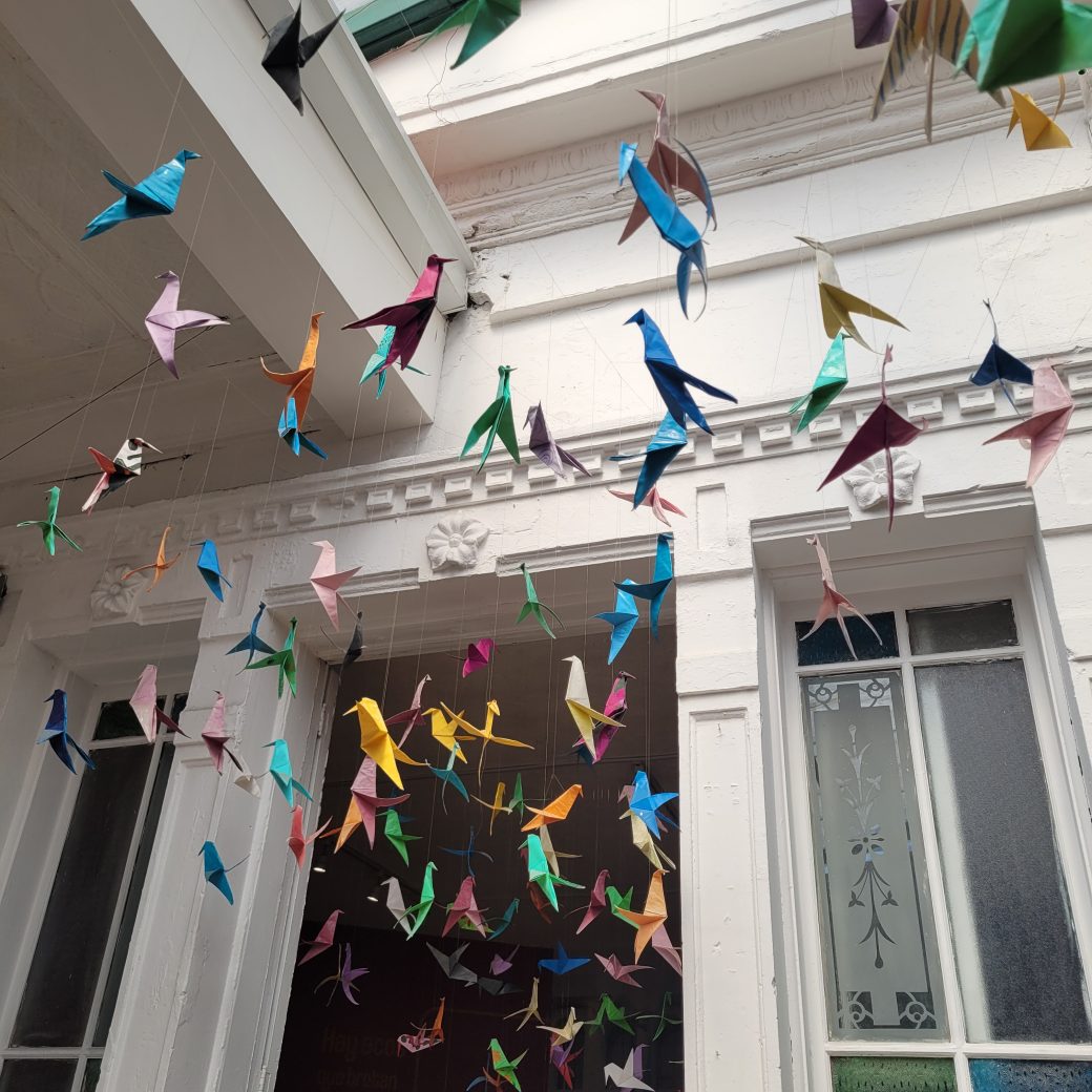 Colorful origami hummingbirds suspended from the ceiling.
