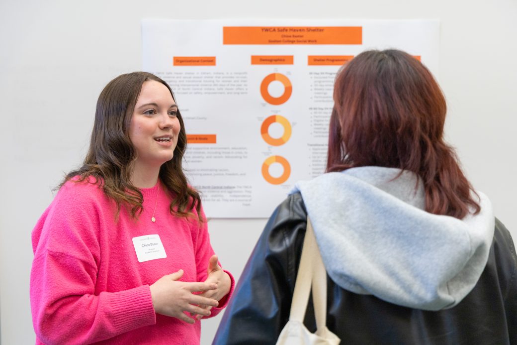 Student talking to group about poster
