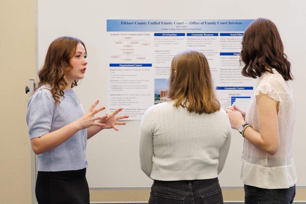 Student talking to group about poster