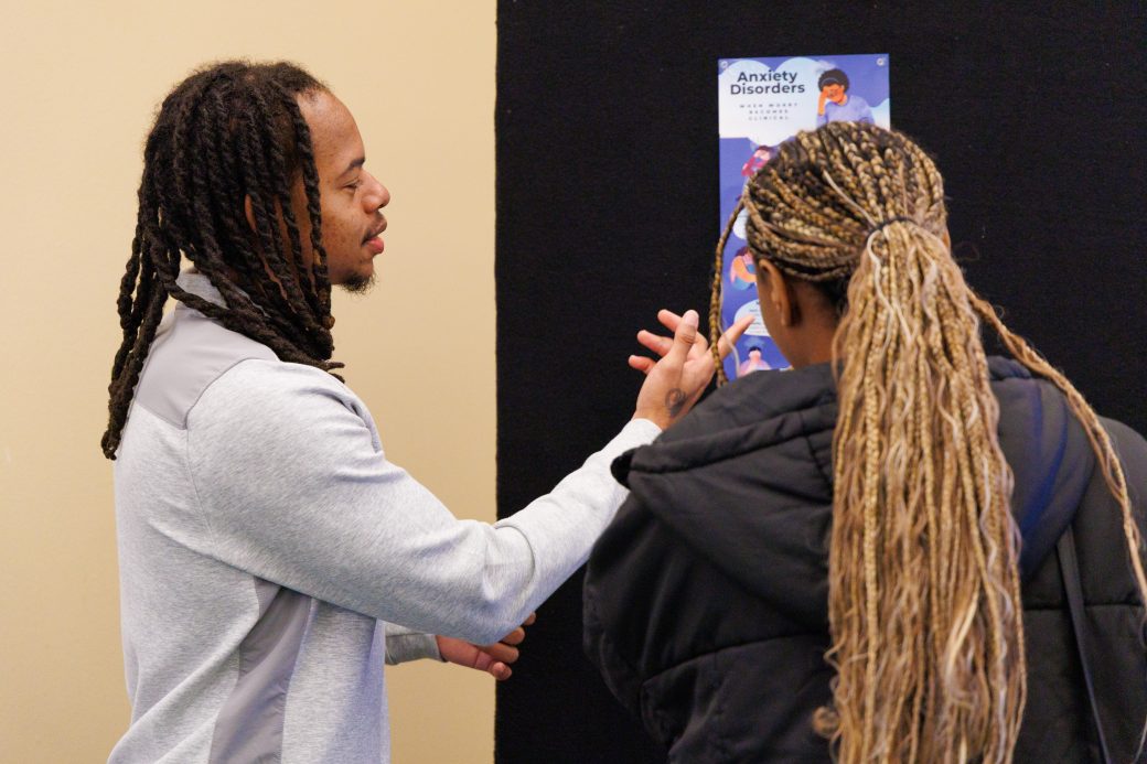 Student talking to student about poster