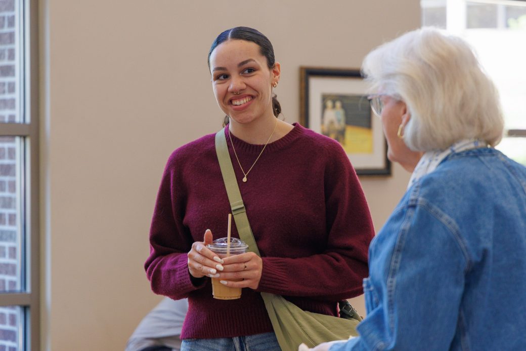 Student smiling at faculty talking