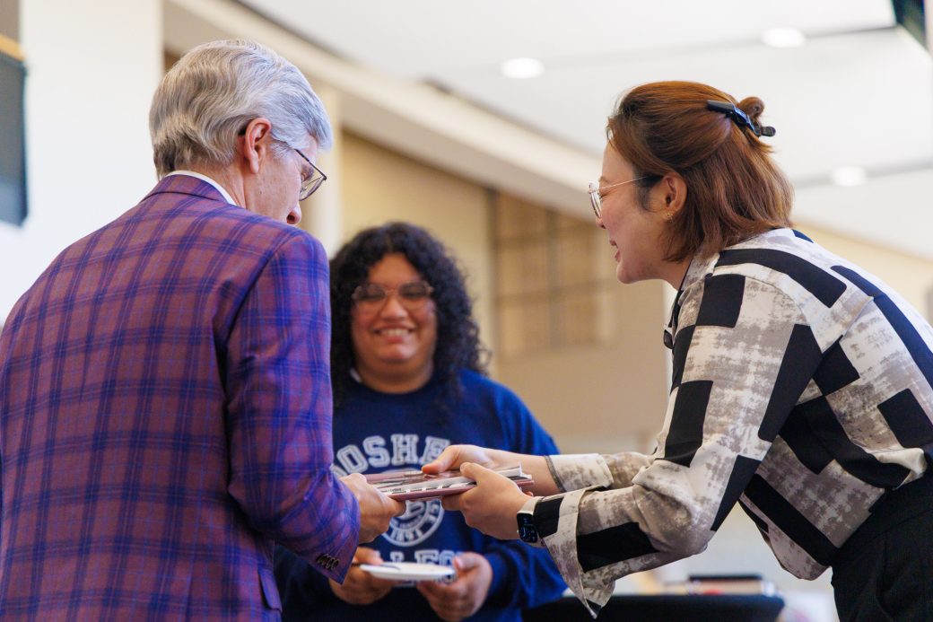 Students and faculty talking and giving gifts