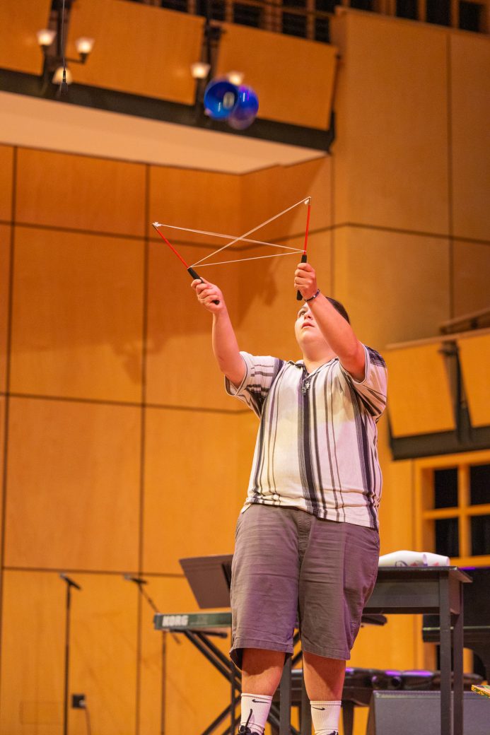 Student throwing spinning top with string