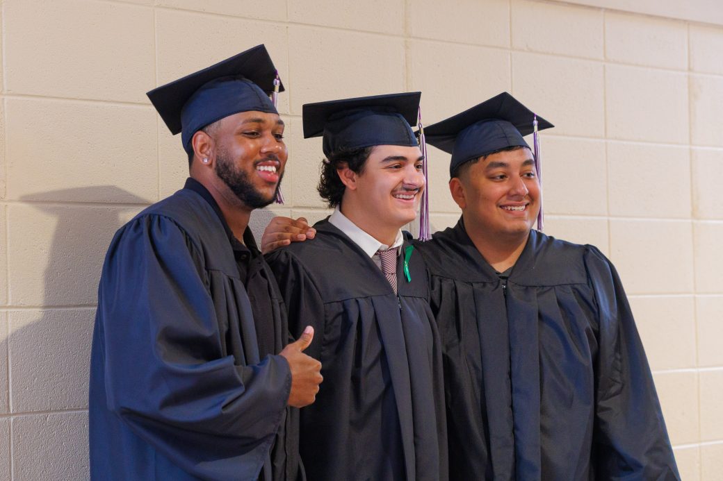 Three graudate men smiling