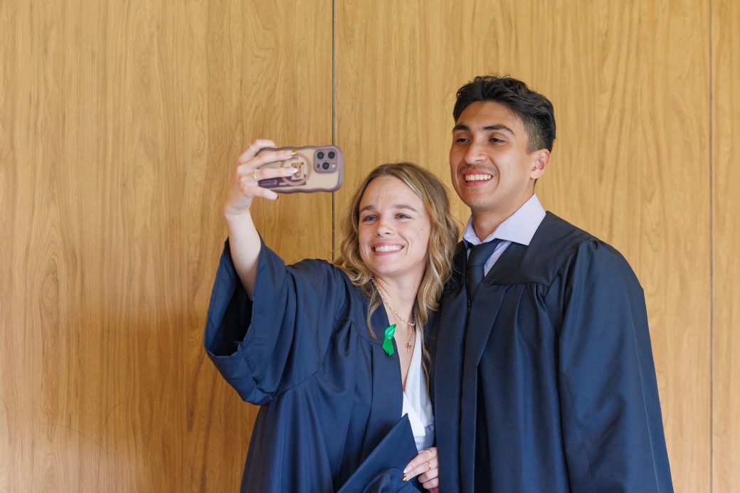 Male and female graduates taking a selfie