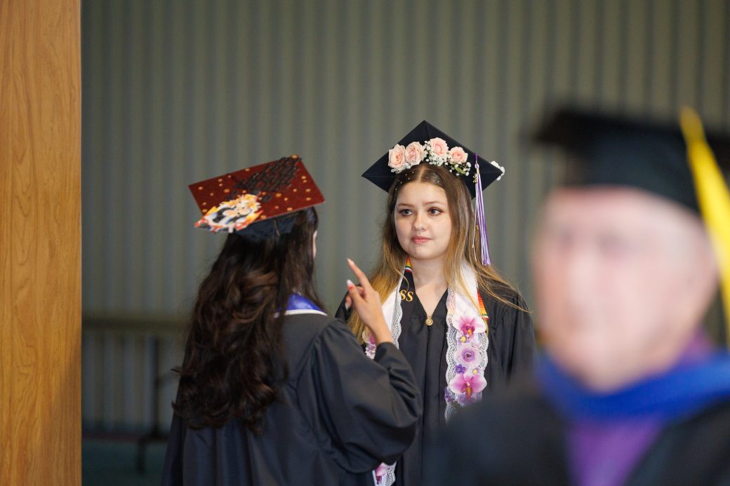 Two female graduates in close conversation